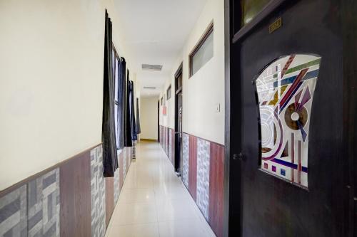 a hallway with a row of paintings on the walls at Collection O Jhalwar Road in Kota