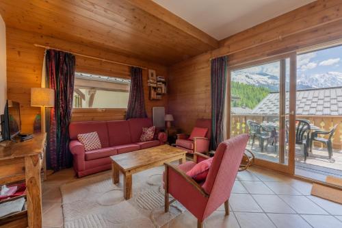 Terrasse Bec Rouge Montroc - Happy Rentals في شامونيه مون بلان: غرفة معيشة بها أريكة وطاولة