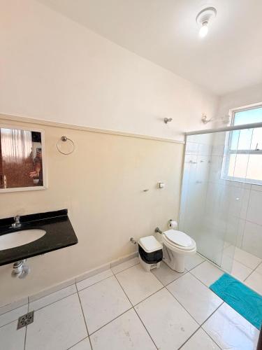 a bathroom with a toilet and a sink and a shower at Hotel Alojamento AS in Americana
