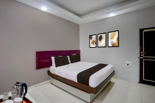 una camera da letto con un letto in una stanza bianca di Super Collection O Paithan Gate Formerly Rajlaxmi Executive ad Aurangabad