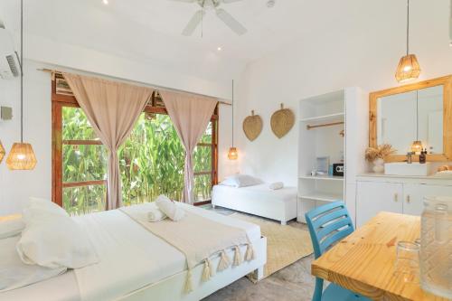 Un dormitorio blanco con una cama y una mesa. en Blauset Two, en General Luna