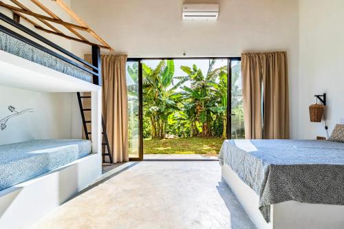 ein Schlafzimmer mit zwei Betten und einem großen Fenster in der Unterkunft Reserva Atmosfëre in Upala