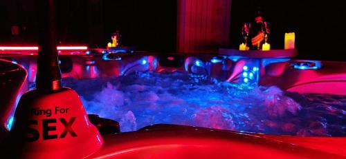 Una habitación con luces rojas y azules sobre una mesa. en Xcoquine Love Room & Spa, en Tourves