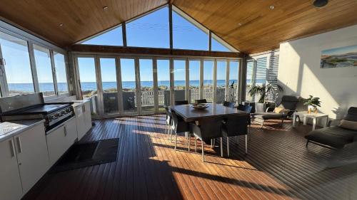 a kitchen and living room with a view of the ocean at THE DECK HOUSE - Beautiful Busselton Beachfront in Busselton