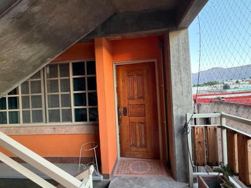 a door of a house with an orange wall at Departamento Nuevo Céntrico con vista hacia la catedral in Saltillo