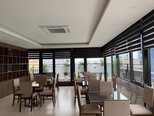 河内A89 Premier Sky Residence Stadium View的餐厅里有桌椅和窗户。