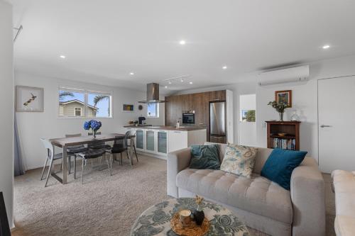 a living room with a couch and a table at Endless Summer Retreat - Mt Maunganui in Mount Maunganui