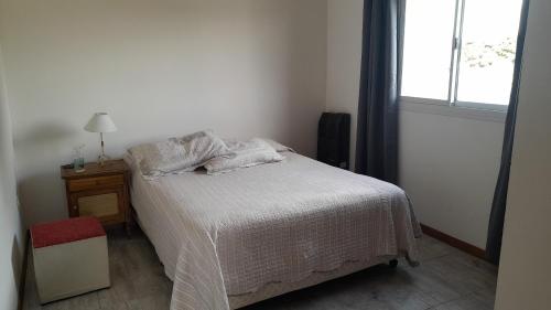 a small bedroom with a bed and a window at Namaste in Olavarría