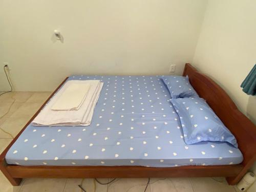 Phú MỹNha Nghi Phu Gia的一张床，床垫是蓝色波点图案的。