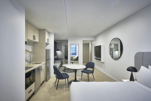 Una cocina y una sala de estar con mesa y sillas. en Meriton Suites Pitt Street, Sydney, en Sídney