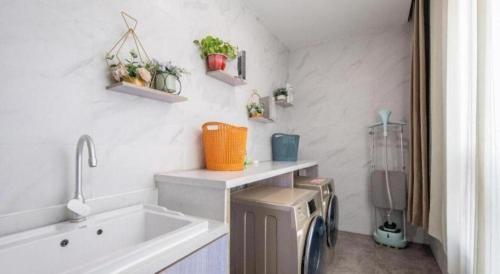 a bathroom with a sink and a washing machine at Jinjiang Inn Select Heze Wanxiang Plaza Guiling Road in Zhaolou