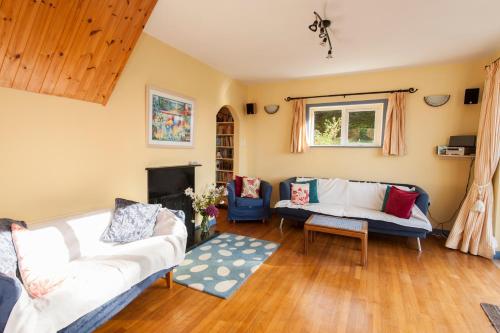 a living room with two couches and a fireplace at Dunmanus Cottage West Cork in Durrus