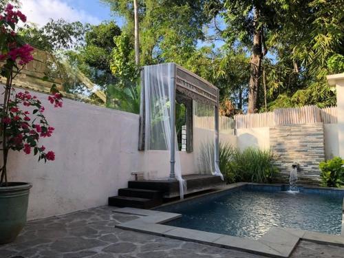克罗柏坎Villa Bliss - 1BR Tropical Villa in Kerobokan的一座带游泳池和喷泉的房子