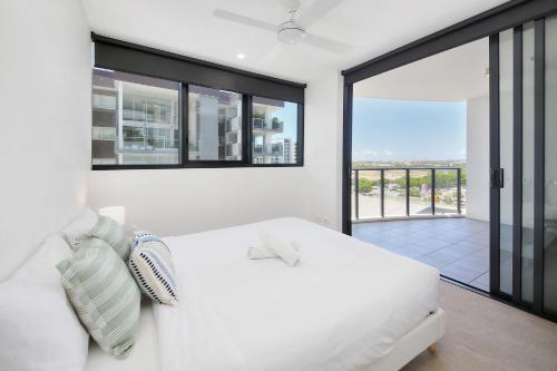 a bedroom with a white bed and a balcony at Riverside Modern Living 2B2B Apt with Parking in Brisbane