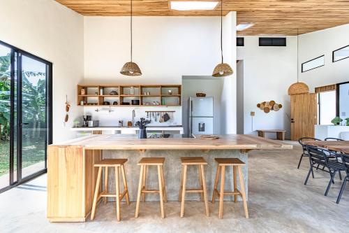una cocina abierta con una gran isla de madera con taburetes de bar en Reserva Atmosfëre, en Upala
