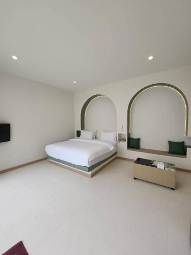ein weißes Schlafzimmer mit einem Bett und zwei Spiegeln in der Unterkunft Villa38 in Pathum Thani