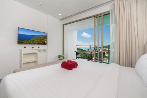 a bedroom with a large white bed and a large window at Studio Apt Seaview Balcony - Oceana C63 in Kamala Beach