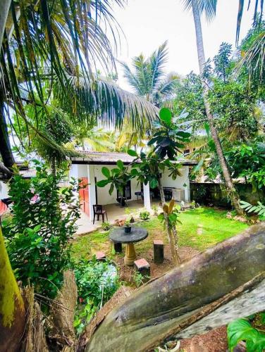 una casa con una mesa en medio de un jardín en Lagoon Home Stay, en Ahangama