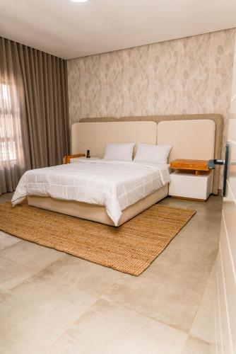 a bedroom with a large white bed and a rug at Villa On 59 in Giyani