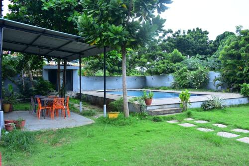 un patio con tavolo e sedie in un cortile di Le Haayt Resort With pool a Pondicherry