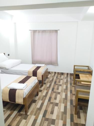 a bedroom with two beds and a piano at Namsay Hotel in Bomdila