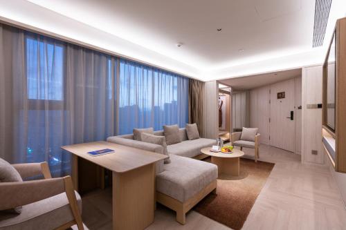 青岛桔子水晶青岛台东步行街延安三路酒店的客厅里有一张沙发和一张桌子。