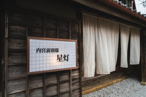 a sign on the side of a building with windows at Naikumae Bettei Hoshiakari in Ise