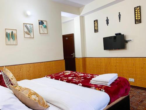 2 Betten in einem Zimmer mit einem TV an der Wand in der Unterkunft Boho Regency in Shimla