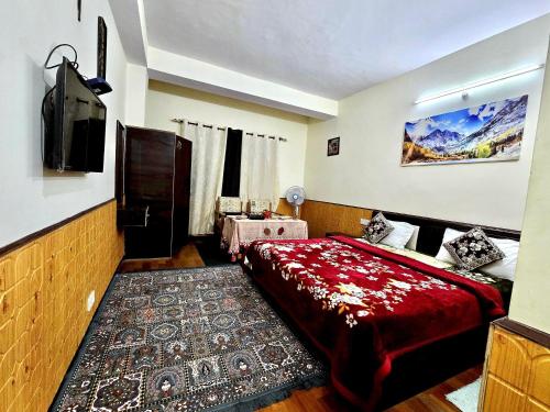 ein Schlafzimmer mit einem Bett und einem Fernseher darin in der Unterkunft Boho Regency in Shimla