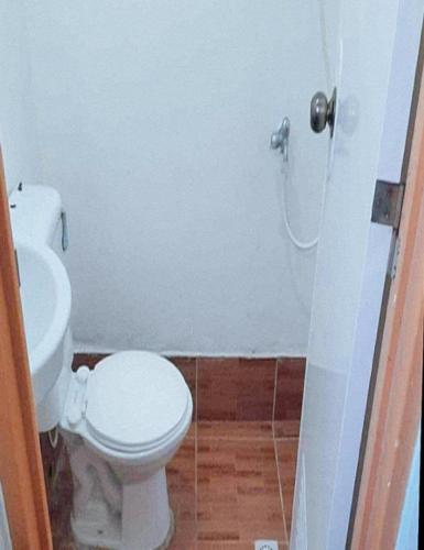 a bathroom with a white toilet and a shower at Balay Baybay Roxas in Roxas City