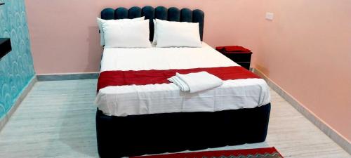 Un dormitorio con una cama grande con una manta roja y blanca. en Hotel O TOYBOX, en Dānāpur