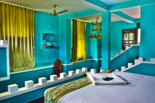耶拉吉里Hill Fort Hotel And Resorts Yelagiri Hills的一间蓝色卧室,配有一张床和电视
