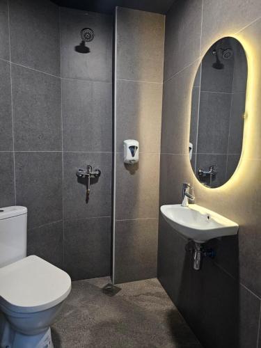 a bathroom with a toilet and a sink and a mirror at Tai Hoe Hotel in Singapore