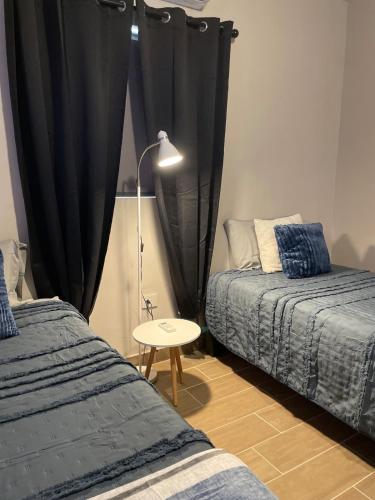 a bedroom with two beds and a lamp and a table at LiV109 Norte Depa 8 Cd Obregon in Ciudad Obregón
