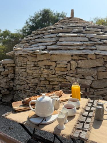 een tafel met een theepot en een kop sinaasappelsap bij Mas de Méjas Chambre d'hôtes La Pierraille in Calvignac