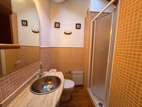 Un baño con lavabo, inodoro y ducha. en La caseta dels jardins, en Osséja