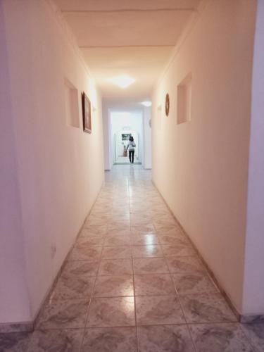a hallway with a tile floor and a person in the distance at Punyu International Hotel in Khomas Region