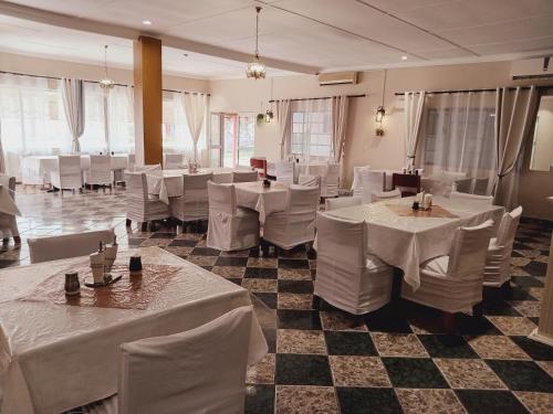 a banquet hall with white tables and white chairs at Punyu International Hotel in Khomas Region