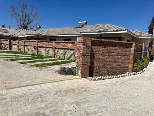 ein Ziegelzaun vor einem Haus in der Unterkunft Hatfield staylax Manor 1 in Harare