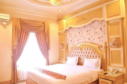um quarto com uma cama grande e uma janela grande em Hotel Grand Town em Pampang