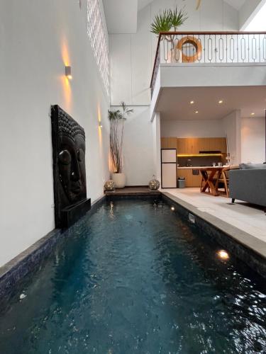 a swimming pool in a room with a house at Villa Jasmine in Seminyak