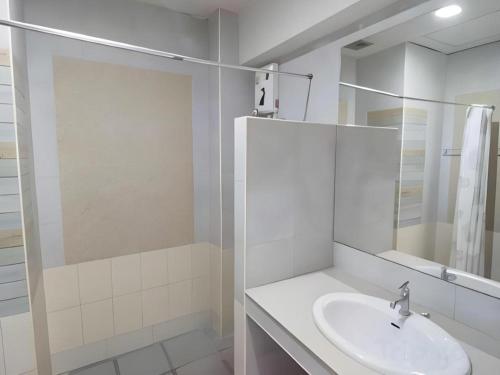 Un baño blanco con lavabo y espejo. en Sea Mountain Khanom Hotel, en Ban Phang Phrao