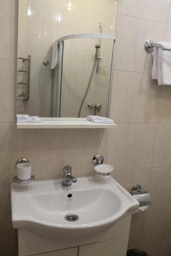 a bathroom with a white sink and a mirror at Hotel Paris in Semenowo