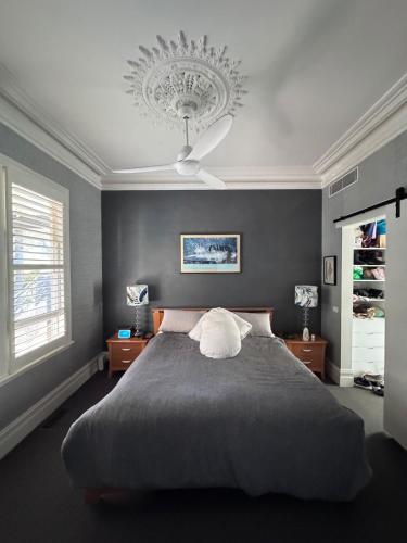 a bedroom with a large bed with a ceiling fan at Inner city quiet cottage in Melbourne