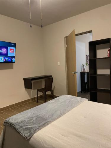 a bedroom with a bed and a desk and a piano at LiV109 Norte Depa 7 Cd Obregon in Ciudad Obregón