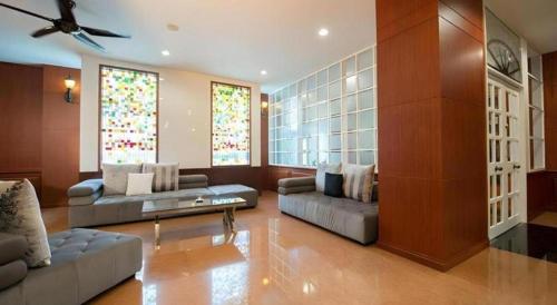 a living room with two couches and stained glass windows at Nartsiri Hotel in Ubon Ratchathani