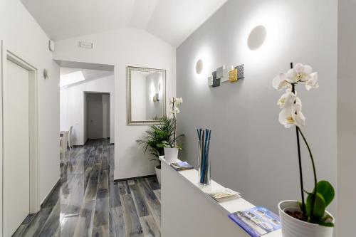 a hallway with white walls and a table with flowers at B&B al Palazzo in Agropoli