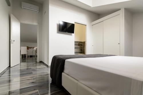 1 dormitorio con 1 cama y TV en la pared en B&B al Palazzo, en Agropoli