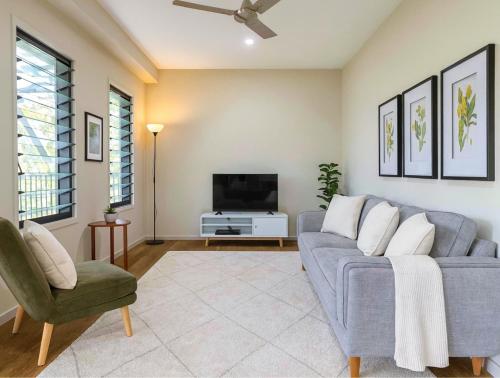 a living room with a blue couch and a tv at Tallebudgera Hinterland Retreat in Tallebudgera