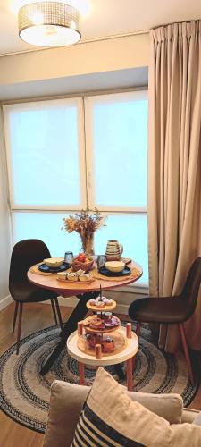 uma sala de estar com uma mesa e duas janelas em ALTZOAN apartamentos Boutique & Parking em Zarautz